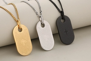 Detail van kruis- en Onzevader-gravure op goud, zilver en zwarte militaire dogtags hangers