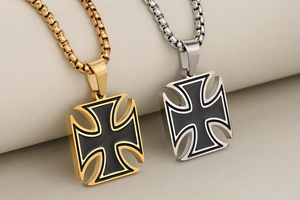 Detailed view of gold and silver iron cross pendants with black enamel on box chains
