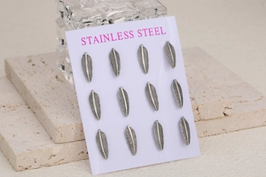 Detailed view of 12 stainless steel leaf pendants for jewelry making on white card