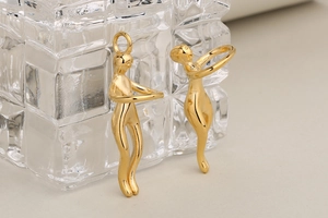 Detalle de colgantes dorados abstractos de pareja abrazada para creación de joyas