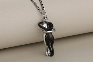 Primer plano del colgante de abrazo bicolor con acabados en plata pulida y metal negro