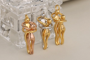 Detalle de tres colgantes de abrazo en oro, oro rosa y acero inoxidable bicolor pulido