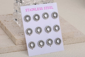 Détail de six paires de boucles d'oreilles en acier inoxydable avec halo de strass