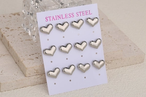 Detail shot of twelve silver heart-shaped stainless steel stud earrings on a card