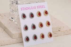 Detail of tear-drop crystal earrings with red faceted stones and stainless steel base