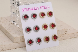 Détail de six paires de boucles d'oreilles en acier inoxydable avec cristaux rouges