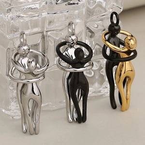 Colgantes de pareja abrazada en acero inoxidable con acabados plata, negro y oro