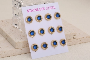 Détail de boucles d'oreilles en acier inoxydable doré avec pierres bleues et cristaux