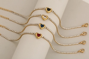 Primer plano de pulseras de tenis doradas con cristales de colores en forma de corazón