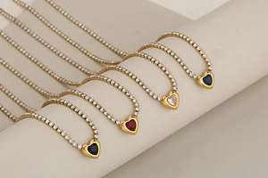 Détail de colliers tennis en forme de cœur en quatre couleurs avec chaîne en zircon doré