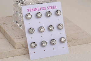 Macro view of twelve stainless steel stud earrings with round crystals on display