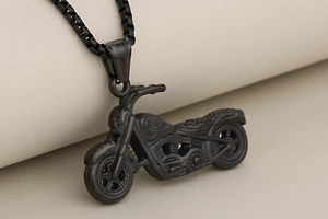 Macro d'un pendentif moto noir mat avec crâne décoratif sur une chaîne maille vénitienne