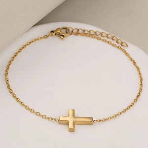 Poliertes Edelstahl Gold Kreuz Armband mit O-Kette und Karabinerverschluss auf weißem Sockel