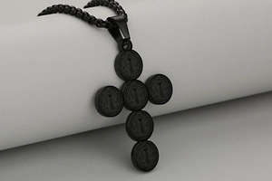 Macro detail of black stainless steel cross pendant featuring Saint Benedict medals and box chain