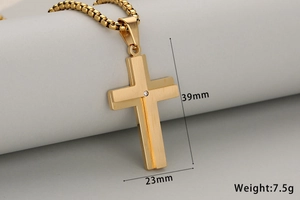 Detalle del colgante cruz de acero dorado 39x23mm con circonita y cadena de caja moderna