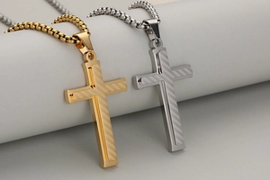 Detailed view of layered stainless steel cross pendants with striped brushed texture