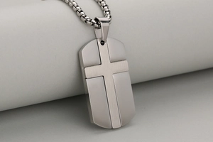 Detail des Kreuz-Dog-Tag-Anhängers mit polierten Kanten und gebürsteter Metalltextur