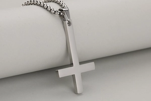 Macro-opname van gepolijste roestvrijstalen omgekeerd kruis hanger en stevige ketting
