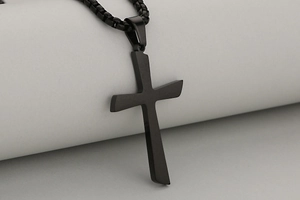 Macro shot of matte black stainless steel cross pendant with matching round box chain detail
