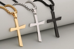 Detailed view of polished cross pendants in gold, silver, and black finish with box chains