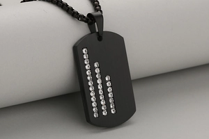 Detail of black matte stainless steel military tag pendant with vertical set crystals