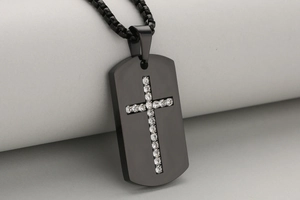 Dettaglio macro della collana militare nera in acciaio con croce di diamanti lucidi