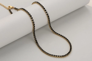 Detaillierte Nahaufnahme der 3mm Gold-Tenniskette mit schwarzen quadratischen Zirkonia