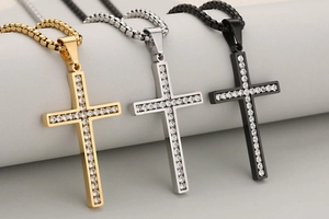 Macro-opname van iced-out kruis hangers in goud, zilver en zwart roestvrij staal