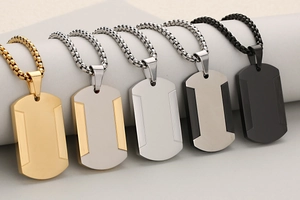 Dettaglio di cinque pendenti a targhetta in acciaio inossidabile con design puzzle