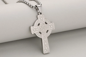 Gros plan d'un pendentif croix à nœud celtique en acier inoxydable argenté poli