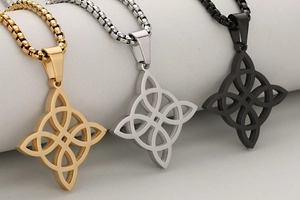Detailansicht von Keltenknoten-Anhängern in Gold, Silber und Schwarz an einer Box-Kette