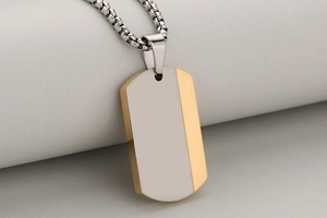 Detail showing two-tone gold and silver stainless steel dog tag with box chain