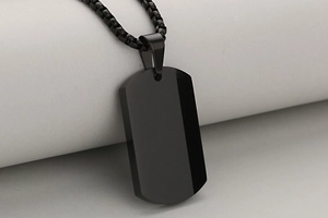 Macro view of polished black stainless steel military tag pendant with glossy mirror finish