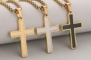 Macro detail of brushed stainless steel cross pendants with gold and black inlays