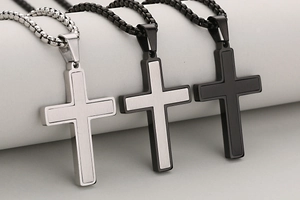 Detail showing matte and brushed stainless steel cross pendants in silver and black finishes