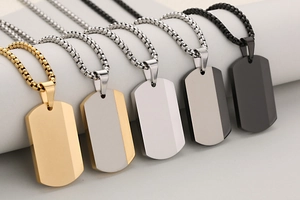 Close-up of stainless steel dog tag necklaces in gold, silver and black finishes