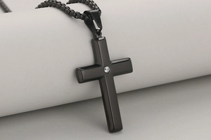 Close-up of black stainless steel cross pendant with a centered round zircon stone