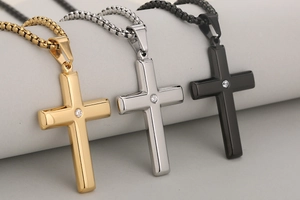 Detailed close-up of polished stainless steel cross pendants with central zircon stones