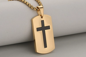 Macro view of gold and black stainless steel cross dog tag pendant with beaded chain