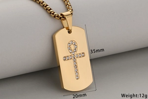 Detailed view of a gold dog tag necklace with an Ankh cross, measuring 35mm by 20mm