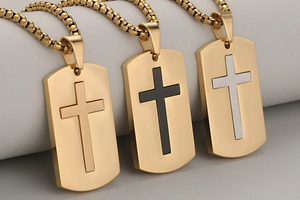 Detailed view of stainless steel cross dog tag pendants in gold, black, and silver finishes