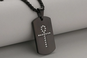Detail of black brushed stainless steel dog tag with stone-studded Ankh cross and box chain