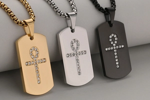 Close-up of brushed stainless steel Ankh cross dog tag pendants in gold silver and black