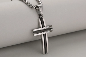 Detail eines polierten Herren-Kreuzanhängers aus Stahl in Silber und Schwarz