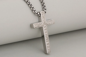 Détail du pendentif croix en acier argenté avec runes nordiques gravées et chaîne box