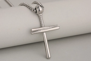 Vue macro du pendentif croix baseball avec détails de couture sur chaîne box