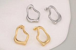 Detailansicht unregelmäßiger hohler Ohrstecker in hochglanzpoliertem Gold und Silber