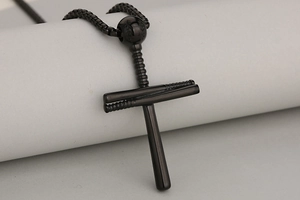 Détail macro du pendentif croix baseball en acier inoxydable noir avec battes de baseball
