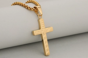 Macro detail of golden American flag pattern engraved on a polished cross pendant