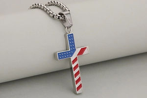 Macro shot of American flag patterns on a stainless steel cross pendant with chain